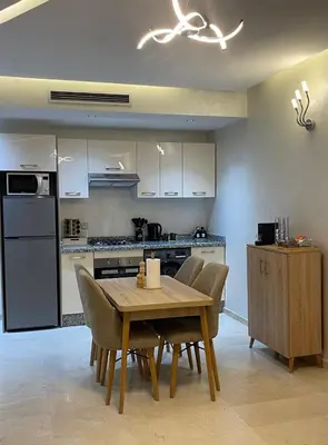 a kitchen with a table and chairs in a kitchen at Appartement luxueux marrakech in Marrakech