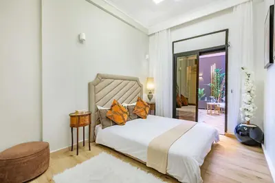 a bedroom with a large white bed and a mirror at Villa YOGA Guéliz Centre-Ville in Marrakech