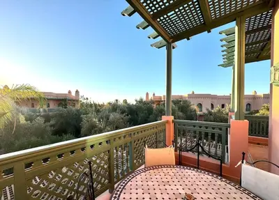 a balcony with a table and chairs on it at Paradis à marrakech Grande Piscine in Marrakech