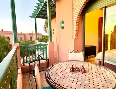 a table on the balcony of a house at Paradis à marrakech Grande Piscine in Marrakech