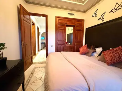 a bedroom with a large white bed in a room at Paradis à marrakech Grande Piscine in Marrakech