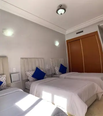 a hotel room with two beds and blue pillows at Tulipe Family House-Pool and Parking in Marrakech