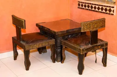 two chairs and a wooden table and a table and chairs at Appartement Riad élégant chic au cœur de Guéliz in Marrakech