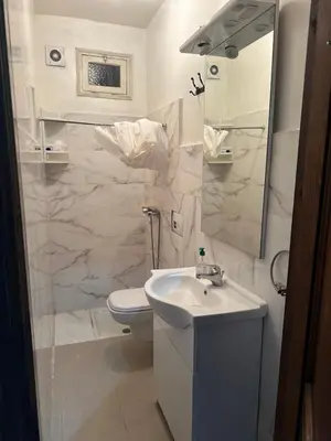 a white bathroom with a sink and a toilet at Appartement Lana Guéliz Marrakech in Marrakech