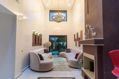 a living room with couches and a chandelier at Duplex with private pool in Marrakech