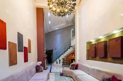 a living room with a couch and a chandelier at Duplex with private pool in Marrakech