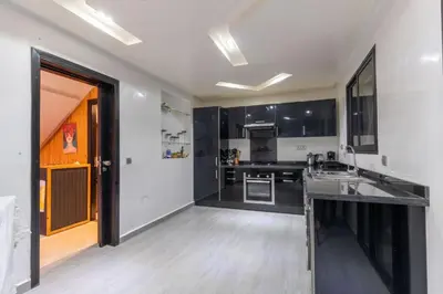 a large kitchen with black and white cabinets at Duplex with private pool in Marrakech
