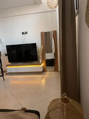 a living room with a flat screen tv on the floor at La Bohéme - Duplex Neuf - Modern & Chic - Proche Gare - Confort - CLIM Parking et WIFI Gratuit ! GUELIZ in Marrakech