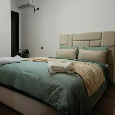 a bedroom with a large bed with green sheets and pillows at superbe appartement à côté de la gare à Gueliz Marrakech in Marrakech