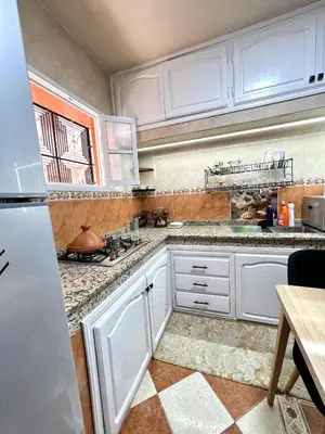 a kitchen with white cabinets and a counter top at Cozy Apartment near airport in Marrakech