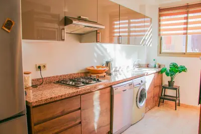 a kitchen with a stove top oven next to a dishwasher at Élégant appart 3 chambres cozy avec piscine in Marrakech