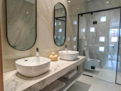 a bathroom with a large white sink and two mirrors at Villa iris in Marrakech