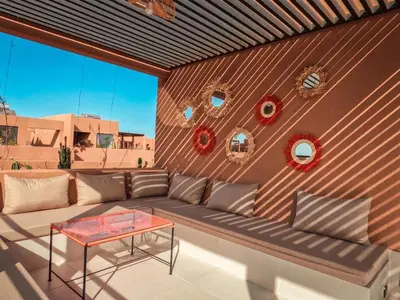 a rooftop patio with a couch and a table at Villa iris in Marrakech