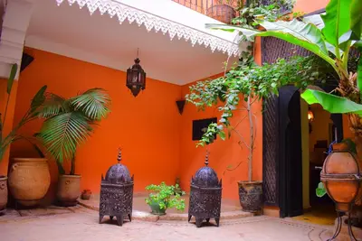 a room with orange walls and potted plants at Riad les ANGES DU DESERT in Marrakech