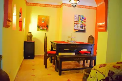 a room with a piano and a table in it at Riad les ANGES DU DESERT in Marrakech