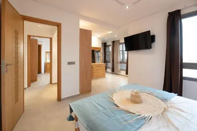 a room with a bed with a flat screen tv at Villa Targa in Marrakech