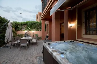 a hot tub in a patio with a table and chairs at Villa Targa in Marrakech