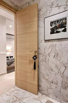 a wooden door in a room with a marble wall at Charming apartment in Agdal in Marrakech