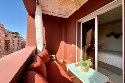 a room with a couch and a table on a balcony at Central Gueliz with Pool and Terrace in Marrakech