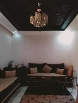 a living room with a couch and a chandelier at Jnan chrifiya in Marrakech