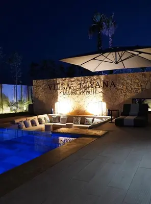 a pool with couches and an umbrella at night at Marrakech Oasis Retreat - 5-Bedroom Villa with Private Pool in El Makina