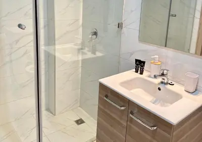 a bathroom with a sink and a shower at Reflet du Désert Appartement bohème à Marrakech in Marrakech