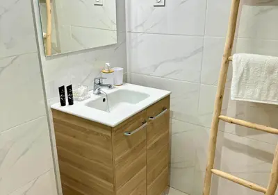 a bathroom with a sink and a mirror at Reflet du Désert Appartement bohème à Marrakech in Marrakech