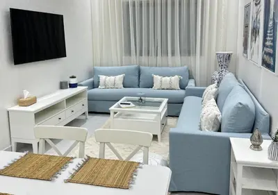 a living room with a blue couch and a table at Sérénité Berbère Appartement centre Marrakech in Marrakech