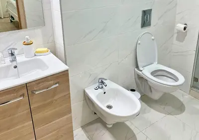 a white bathroom with a toilet and a sink at Sérénité Berbère Appartement centre Marrakech in Marrakech