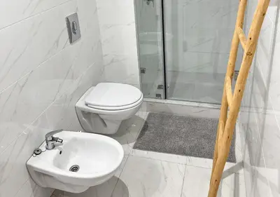 a white bathroom with a toilet and a sink at Sérénité au coeur de Marrakech in Marrakech