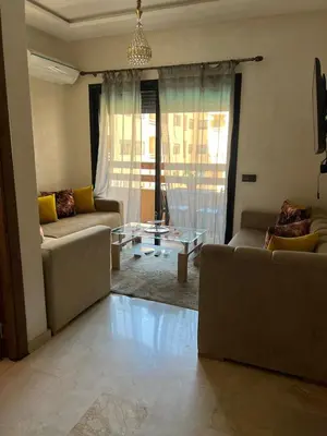 a living room with two couches and a glass table at Cozy Nour in Marrakech
