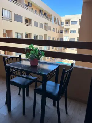 a table and chairs with a potted plant on a balcony at Cozy Nour in Marrakech