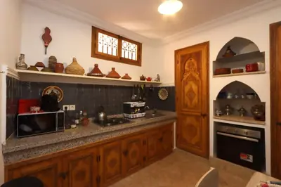 a kitchen with wooden cabinets and a counter top at Riad Dutilleul in Marrakech