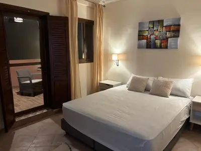 a bedroom with a white bed and a sliding glass door at Joli appartement à Gueliz in Marrakech