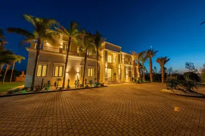 a large house with palm trees in front of it at White Mansion in Tameslouht