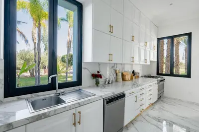 a kitchen with white cabinets and a sink at White Mansion in Tameslouht