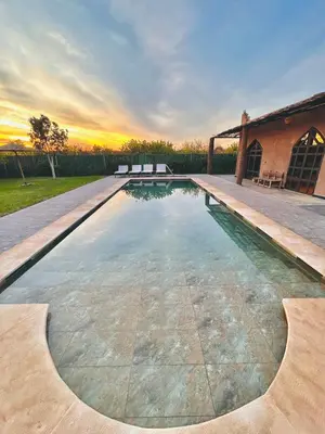 a swimming pool with a sunset in the background at Villa piscine privée sans vis à vis, 20 min du Centre - Fibre Optique Wifi in Marrakech