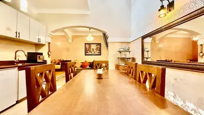 a kitchen with a long wooden table in a room at Edwiria Marrakech in Marrakech