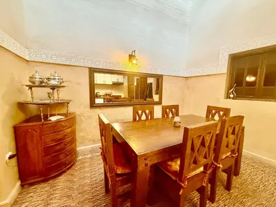 a dining room with a wooden table and chairs at Edwiria Marrakech in Marrakech