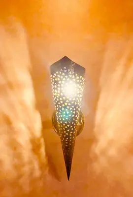 a light hanging from a wall with a lamp at Edwiria Marrakech in Marrakech