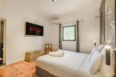 a bedroom with a large white bed and a window at Private villa Comfort and Relax Pool in Marrakech