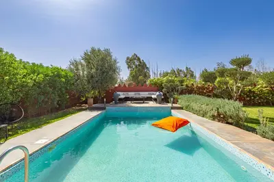 a swimming pool with an orange umbrella in a yard at Private villa Comfort and Relax Pool in Marrakech