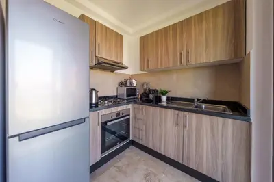 a kitchen with wooden cabinets and a white refrigerator at Elegance and Serenity at Noria Golf and Pool view in Marrakech