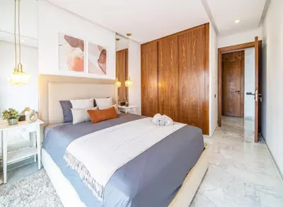 a bedroom with a large bed and a wooden door at Bohemian Style in Hyper-Center - Optical Fiber in Marrakech