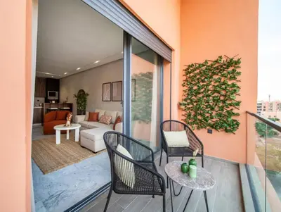 a balcony with two chairs and a living room at Bohemian Style in Hyper-Center - Optical Fiber in Marrakech