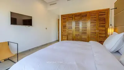a bedroom with a large white bed and a television at VilLA AYDEN in Marrakech