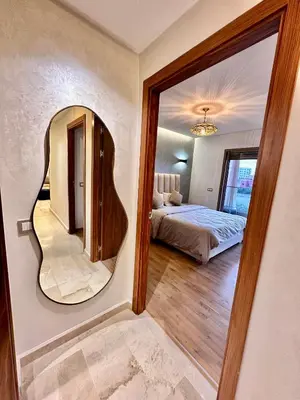 a bedroom with a bed and a mirror on the wall at Pearl Garden Appart 2 chambres Luxe Cosy Moderne in Marrakech