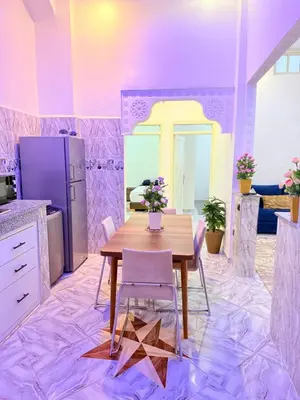 a kitchen with a table and chairs in a room at Appart Cosy Près de laéroport Adapté au Famille in Marrakech