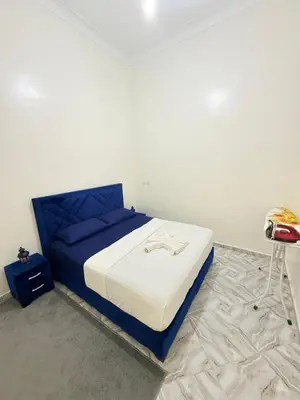 a bedroom with a blue and white bed in a room at Appart Cosy Près de laéroport Adapté au Famille in Marrakech