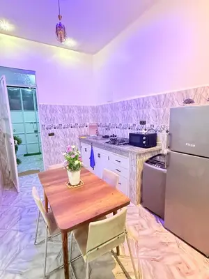 a kitchen with a wooden table and a refrigerator at Appart Cosy Près de laéroport Adapté au Famille in Marrakech